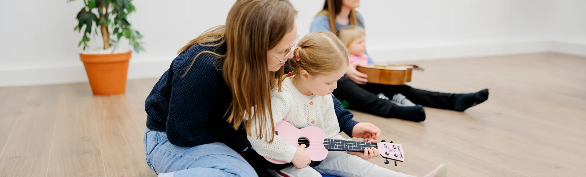 Äiti soittaa lapsen kanssa ukulelea
